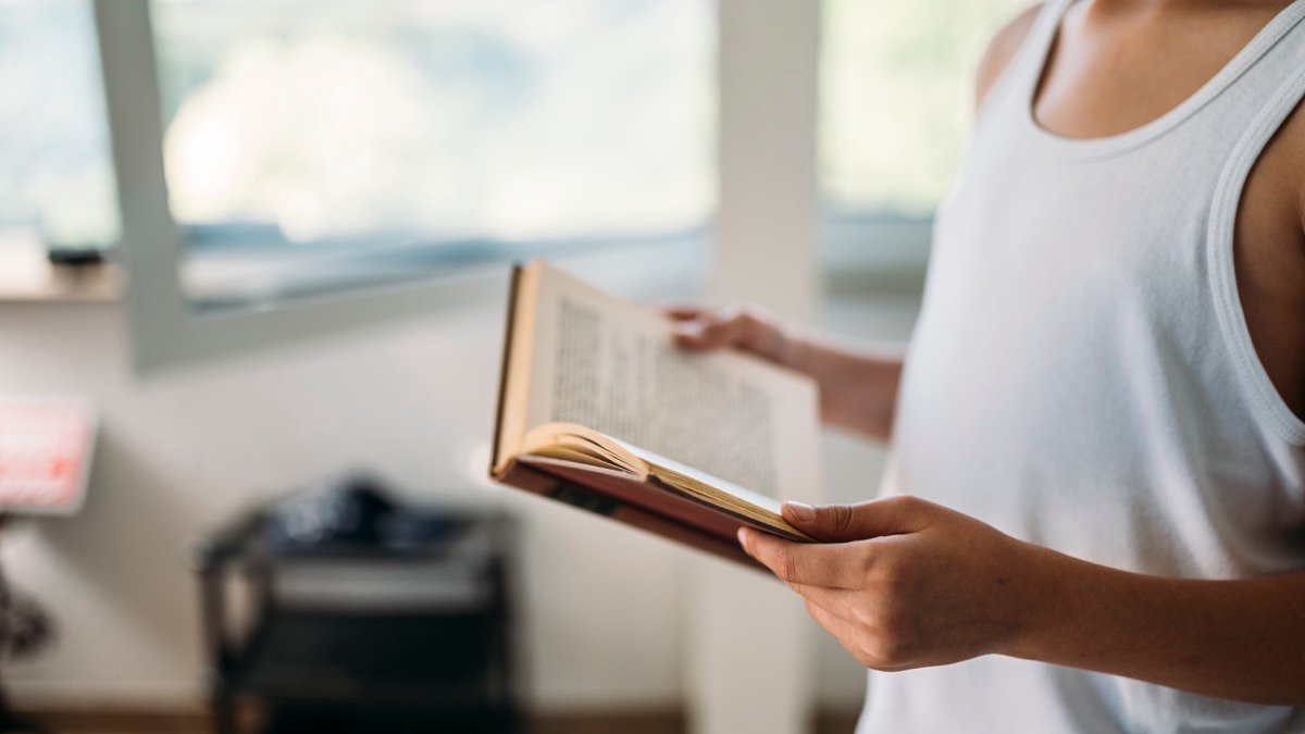 一個人在明亮室內閱讀紙本書，象徵把注意力從待辦清單拿回來