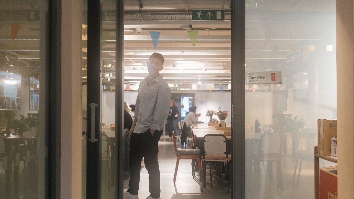 一名工作者站在開啟的辦公室門口